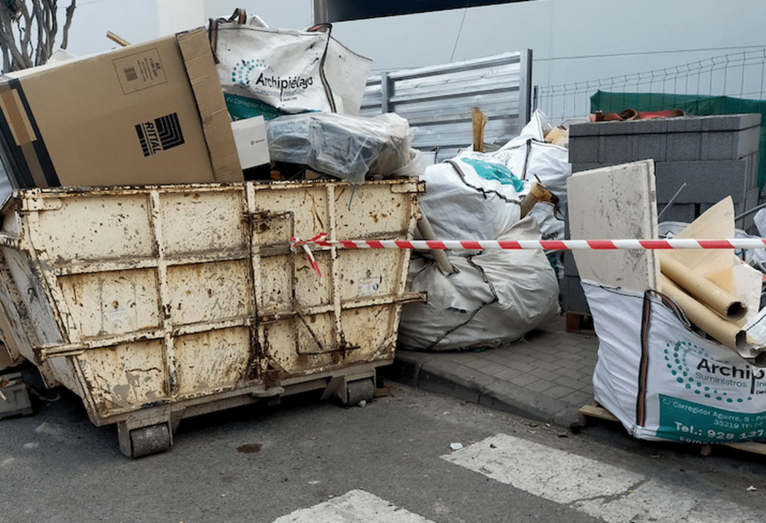 Materiales y elementos de construcción bloquean la acera en la calle 